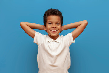 african american teenage boy in white polo resting and lying on blue isolated background, lazy child relaxing