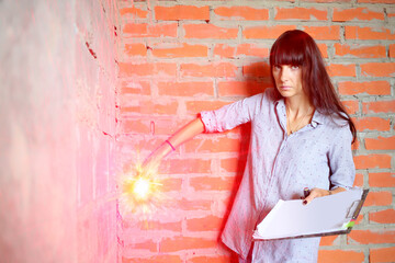 Woman with long hair making marks on the wall using laser level in newly built room