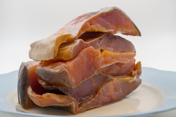 Stacked cold-smoked rainbow trout on serving dish, delicately layered, omega-3 fatty acids, artisanal smoking process, gourmet fish preparation. Culinary art, appetizing, nutritious, ready-to-serve