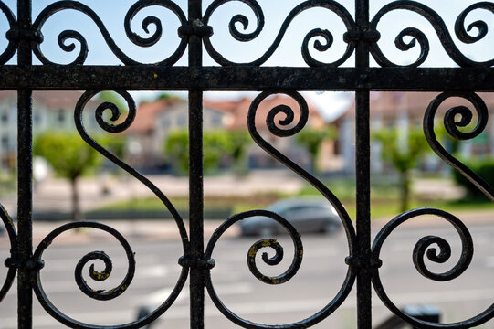 Detail of a wrought iron fence on a street in the city. Selective focus.