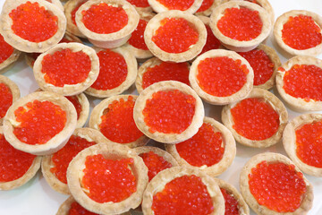 Tartlets with red salmon caviar on plate