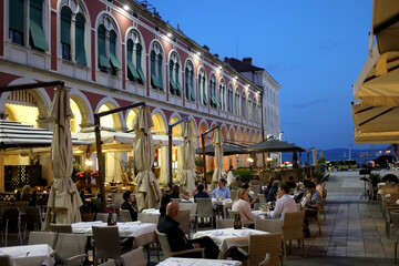 Restaurant with people on Square in the City of Split in Croatia at the evening