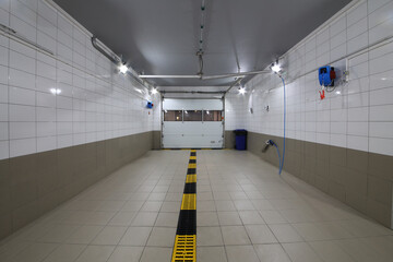 Empty clean car wash room with drainage device and lifting gate