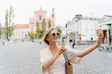 Happy female using smart phone on the Triple bridge in Ljubljana, Slovenia, Europe. - 762269813