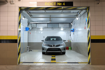 Clean silver car in car wash room in an underground car park