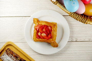Easter Eggs in the basket with bakery cake fresh baked on white wooden table background