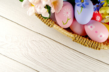 Easter Eggs in the basket with bakery cake fresh baked on white wooden table background