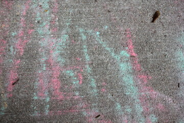 Pink and green chalk scribbles on the sidewalk.