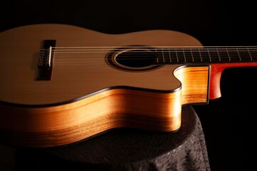 Classical Spanish flamenco guitar close up, dramatically lit isolated on black background with copy...