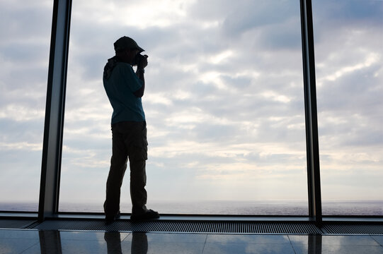 Silhouette of boy who takes pictures of the sky over the sea