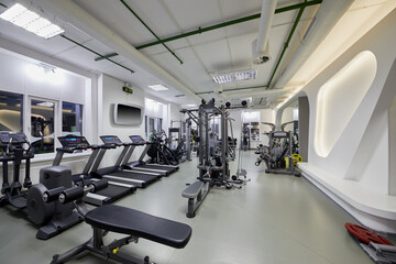 Modern gym room with plenty of fitness equipment.