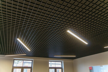 Designer LED lamp on the office ceiling. Interior lighting. Decorative elements on the ceiling.