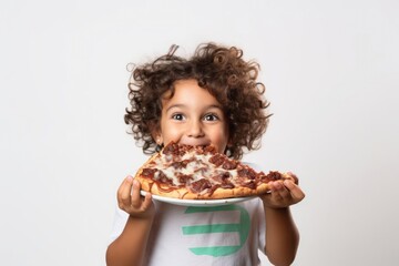 A little boy brings a large piece of delicious pizza cake to his mouth on a white background - obrazy, fototapety, plakaty
