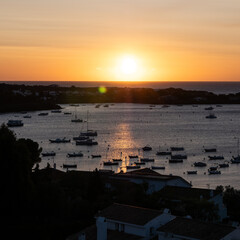 Sunrise over small bay in Spanish town with boats