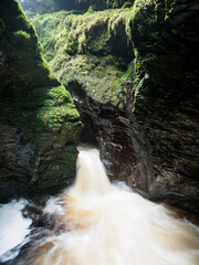 Water rushing through a moss lined gorge in Devon
