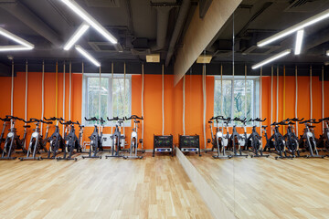 Room with indoor cycling machines and climb ropes in fitness studio.