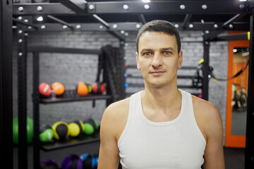 Half-length portrait of man in gym hall of fitness studio.