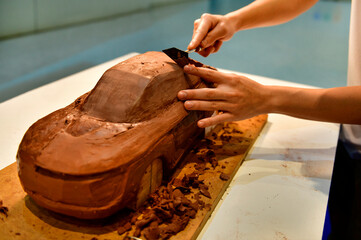 Designers work on the car's sculpture using carving tools. Adjust the surface of the model. in the automotive industry	