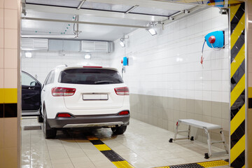 White modern car in cleaning box at underground parking.