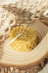Handmade beautiful decorative candle of bee wax on pastel beige background.