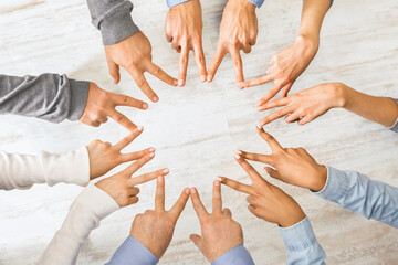 Group of hands showing peace hand sign, top view