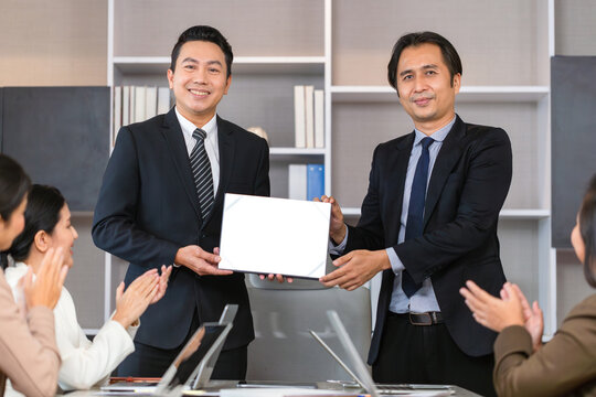 Employee gets a certificate of achievement, Businesspeople with certificate in the office, Businessman giving appreciation certificate to employee for achievement
