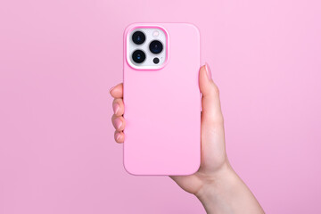 iPhone 15 Pro in female hand in pink silicone cover isolated on pink background phone case mock up in monochrome colours back view