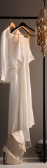 Fashion photography of white clothes on hangers with handbag and lamp