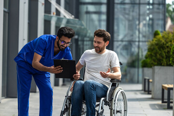 Man sitting in a wheelchair and discussing something with male nurse
