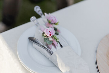 Elegantly arranged tableware with floral accents for a wedding reception. Perfect for catering, event planning
