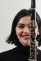 Graceful Brunette Musician Posing with Clarinet on White Background