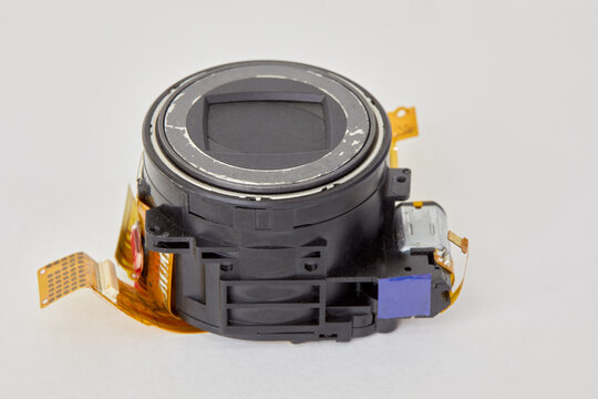 Dismounted old digital camera lens with cables on white background.