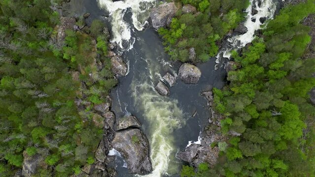 Rauma River in Romsdalen, Rauma Norway, with massive boulders, surrounded by evergreen trees and sno