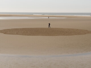 Fototapeta na wymiar Sand art created using a rake on the beach of Conil, Spain