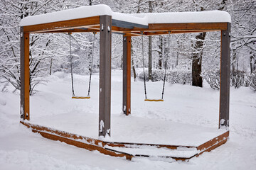 Swings on chains in winter park.