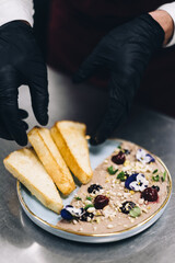The chef prepares the dish. Chef's hand in the frame. Cook on a light background. Cooking....