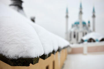Edge of wooden roof covered with snow, shallow dof.