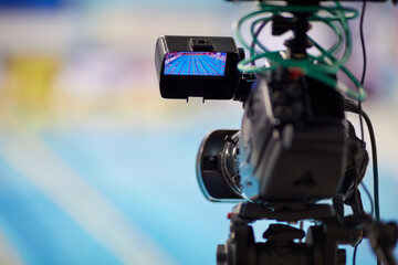 Modern camera during reporting from swimming basin, shallow dof.