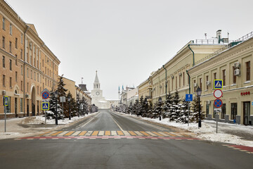 Kremlyovskaya street and Spasskaya tower on winter day. Spasskaya Tower of Kazan Kremlin is its...