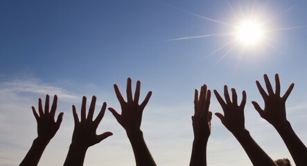 Raised up hands of many people on background of blue sunny sky closeup