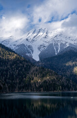 A mountain range with snow on the peaks and a lake in the valley