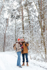 Fototapeta na wymiar Happy mature couple spending time in a snowy forest