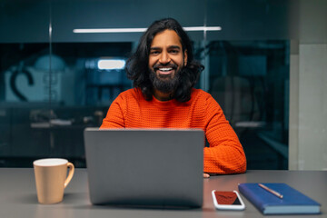 Smiling bearded man with laptop