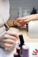 Obraz na płótnie Canvas Manicurist hands make manicure for woman in salon with UV lamp