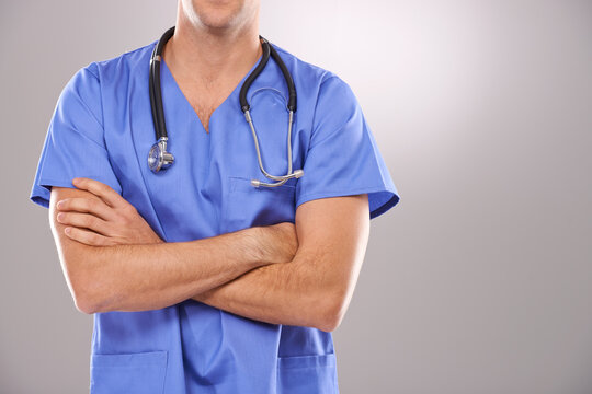 Man, nurse and arms crossed for healthcare in studio, confidence and physician on gray background. Male person, medical expert and pride for medicare, professional and support or help for diagnosis