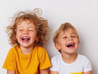 Deurstickers Two young children laughing heartily against a white background, embodying pure joy and happiness. © cherezoff