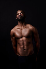 Fototapeta na wymiar Black man, model and muscle with fitness, fashion or masculine figure on a dark studio background. Attractive African, male person or bodybuilder with eyes closed for abs or strength on mockup space