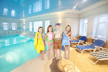 Four happy children in swimwear stand near pool and sunbeds, collage