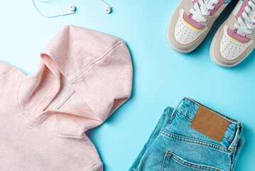 Outfit for teenagers on a blue background. Casual street style, top view point, flat lay.