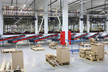 Big empty modern workshop with cardboard boxes, conveyors for sorting of goods